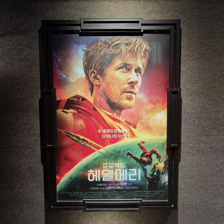 영화관 벽에 걸린 「프로젝트 헤일메리」 포스터. 붉은 우주복 차림의 라이언 고슬링과 ‘두 세계의 운명을 건 단 하나의 미션’ 문구.